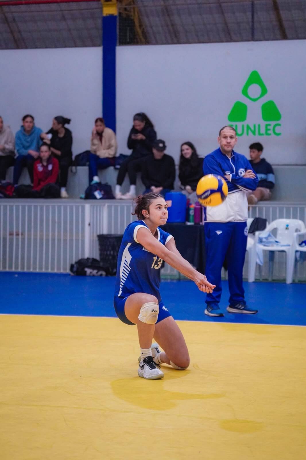 Beatriz Toledo realizando uma recepção durante partida de voleibol